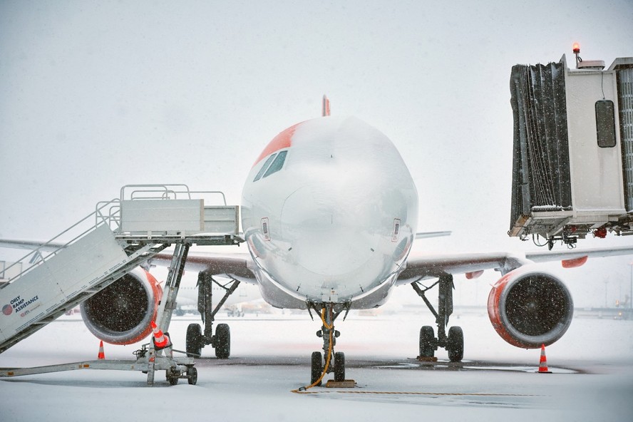 Avião coberto de neve na França, onde houve cancelamentos de voos.