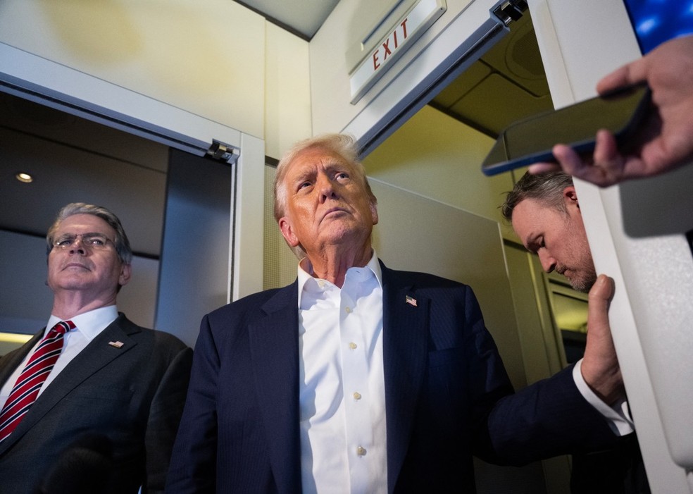 Trump fala com repórteres antes de embarcar para o Japão. — Foto: AFP