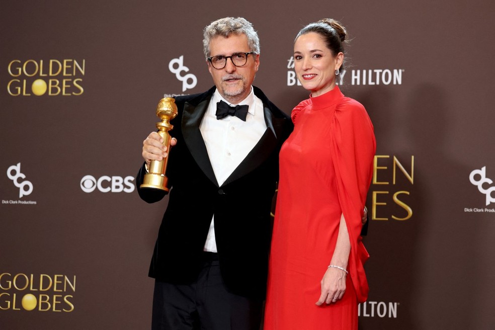 Kleber Mendon&ccedil;a Filho e Emilie Lesclaux, vencedores do Globo de Ouro 2026 na categoria Melhor Filme em L&iacute;ngua N&atilde;o Inglesa, com 'O Agente Secreto'. &mdash; Foto: Foto por AMY SUSSMAN / GETTY IMAGES NORTH AMERICA / GETTY IMAGES VIA AFP