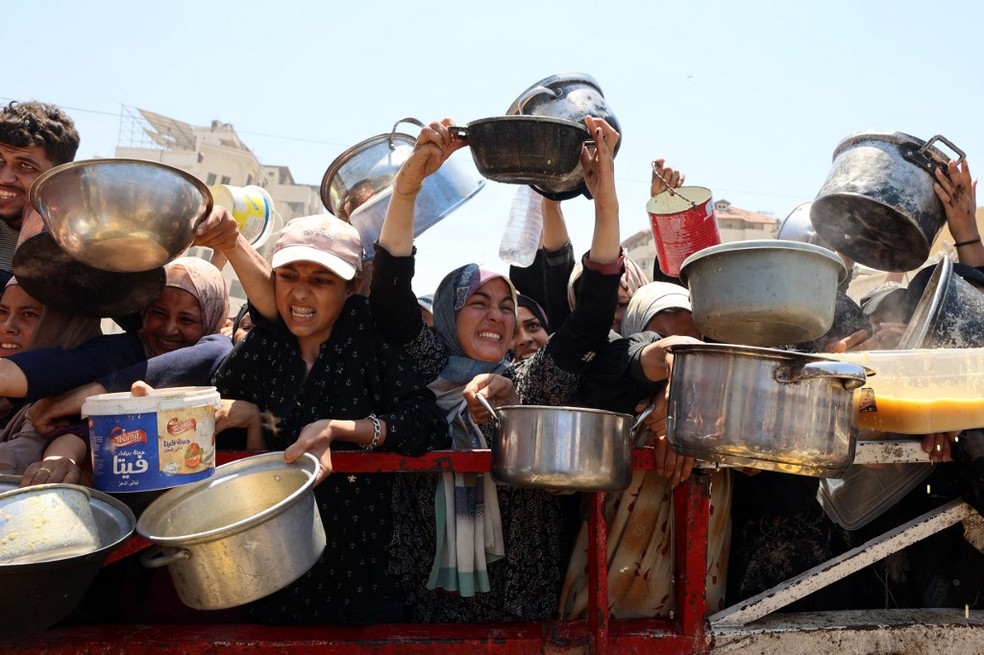 Palestinos na fila para receber sopa em Gaza. — Foto: Omar AL-QATTAA / AFP