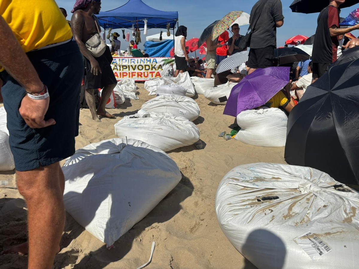 Ambulantes vendem sacos de areia e banquinhos de plástico para servir de 'camarote' durante show da Shakira